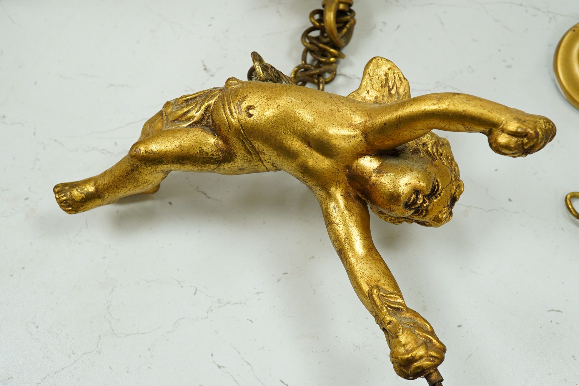 A pair of gilt plaster hanging ‘cherub’ lustre drop light fittings, 24cm long. Condition - fair to good